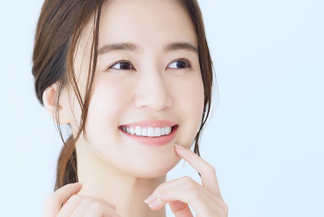 白い歯を見せて笑う女性