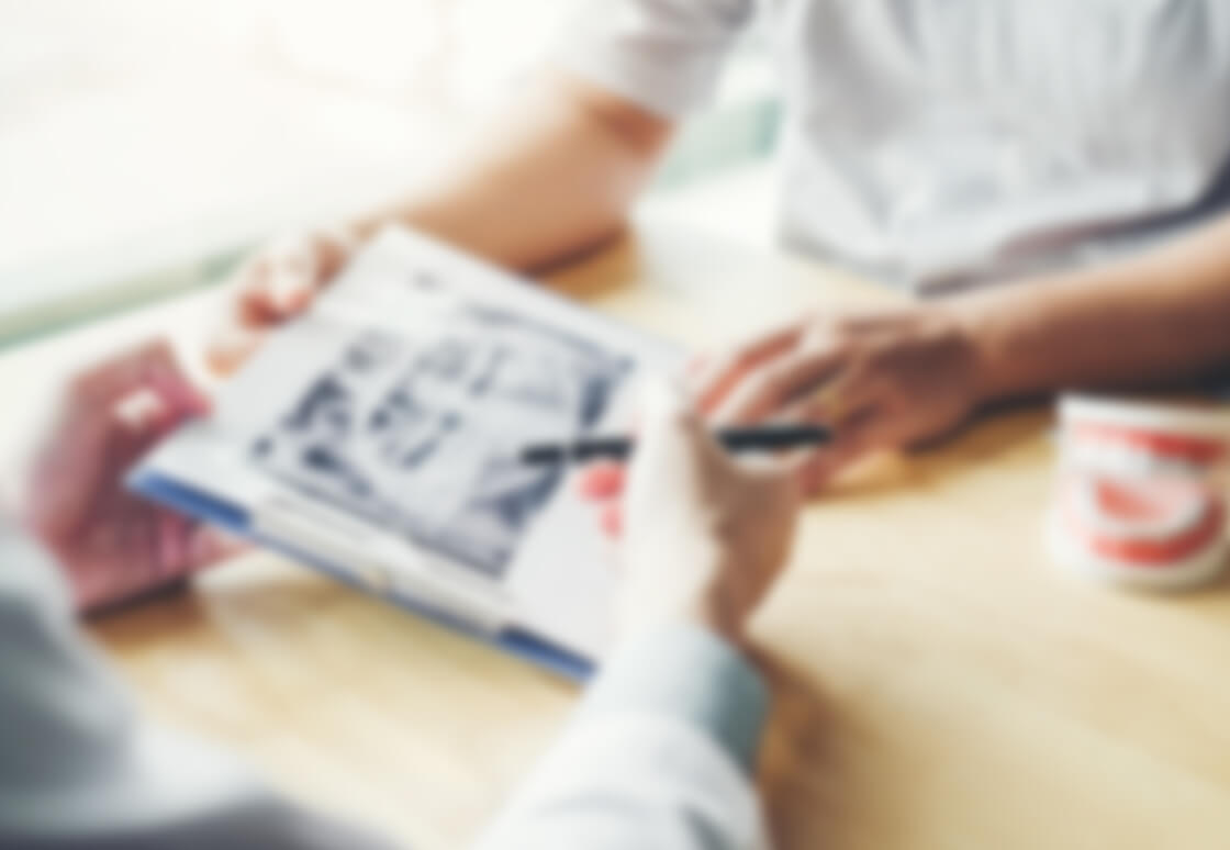 患者に治療内容について説明する歯科医師のイメージ